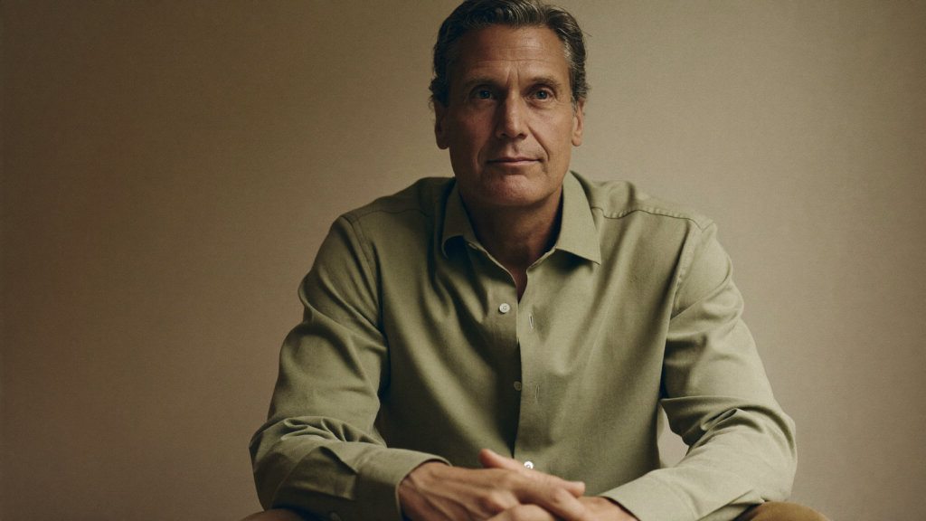 A composed middle-aged man seated near a window in soft natural light, reflecting on a health decision