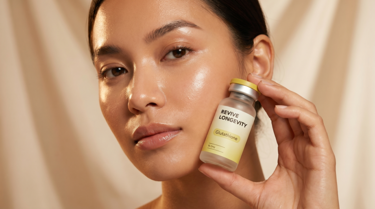 A Revive Longevity glutathione vial in an editorial still-life on a soft sage-green surface