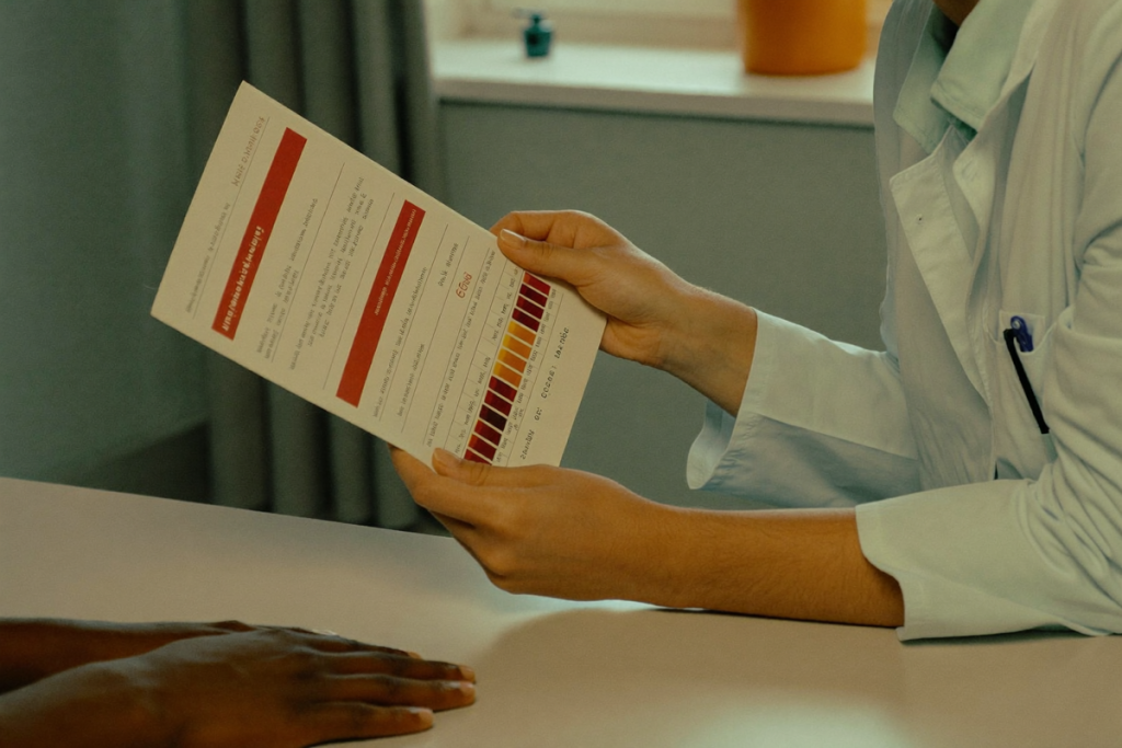 A clinician and patient reviewing lab results together across a table in soft light
