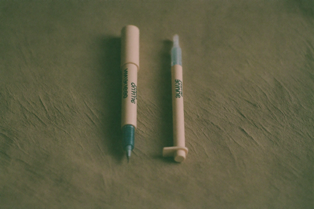 Two plain injection pens side by side on linen, evoking a comparison between two medications