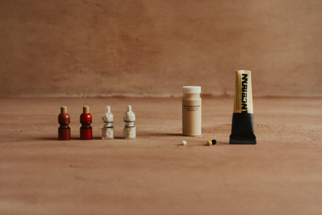 An arrangement of different testosterone delivery forms including a vial and a gel pump bottle on a neutral surface