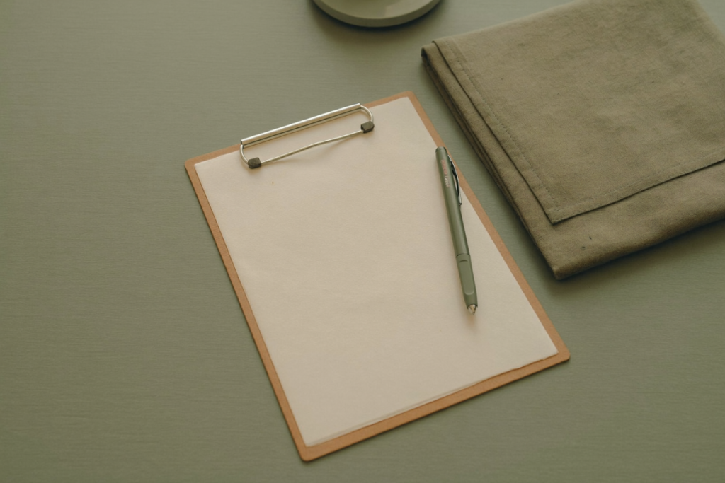 A blank clipboard and pen on a calm desk suggesting a clinical consultation and assessment