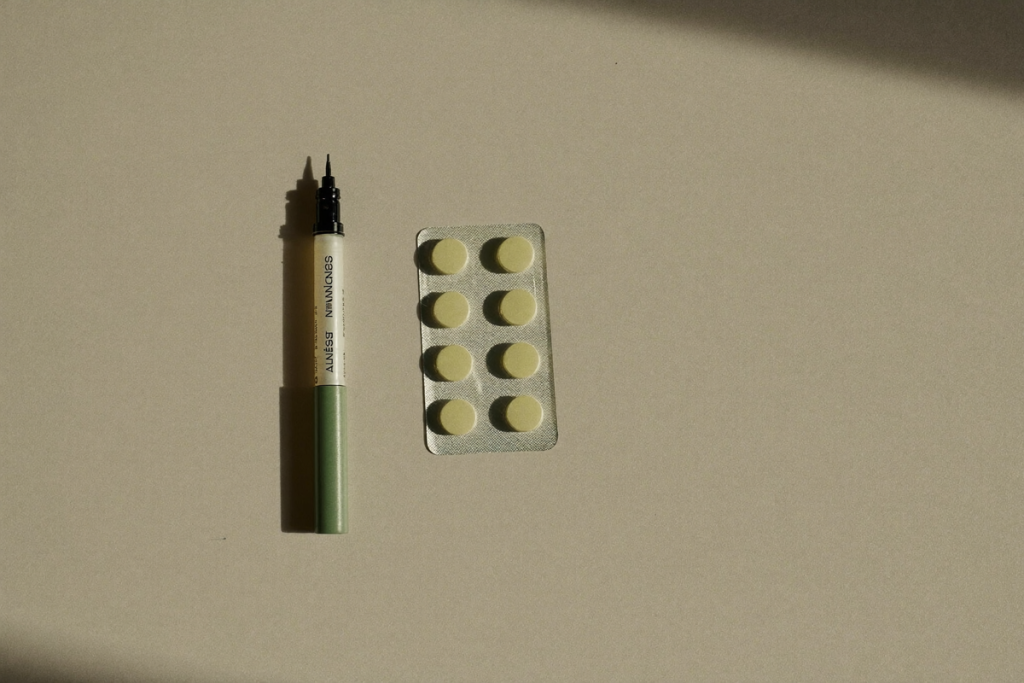 An unbranded autoinjector pen beside a blister pack of tablets on a neutral surface, illustrating PT-141 vs Viagra as two treatment forms