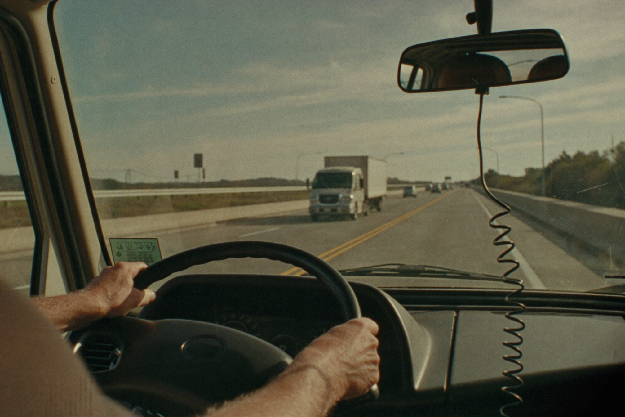 Truck driver at the wheel with open highway ahead
